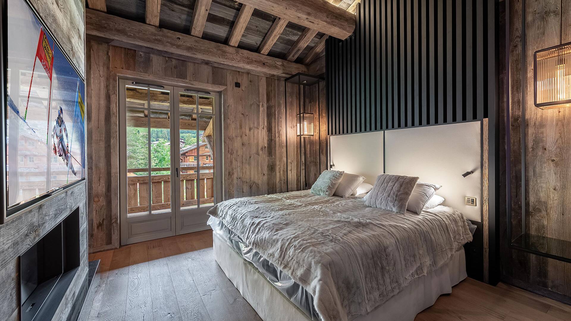 double bedroom with large TV and access to outdoor balcony