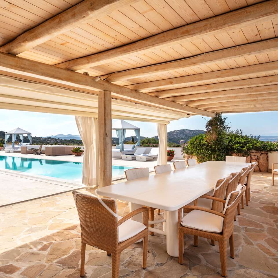 covered al fresco dining area with pool view