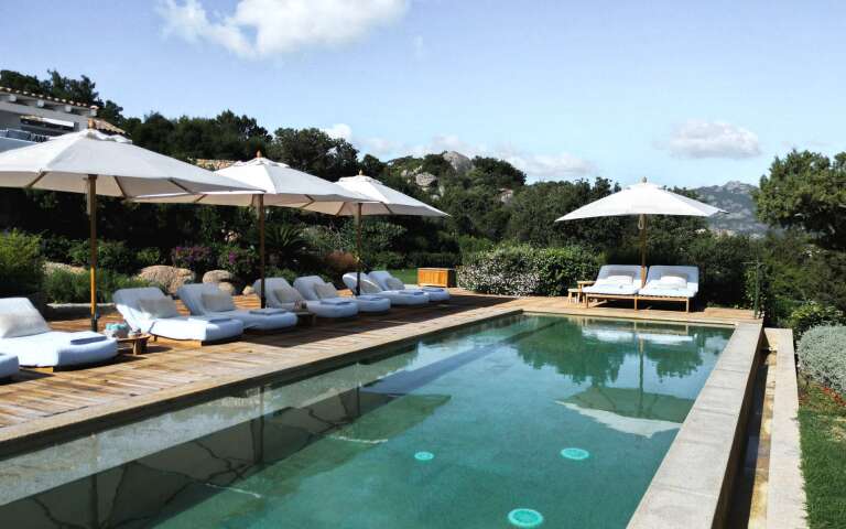 spacious swimming pool equipped with sunbeds and umbrellas 