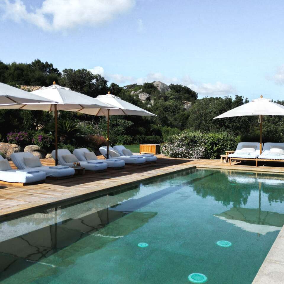 spacious swimming pool equipped with sunbeds and umbrellas 