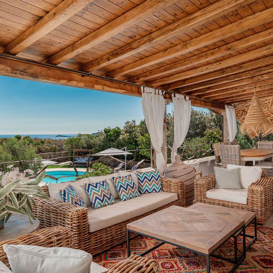 covered sitting area with pool and sea view