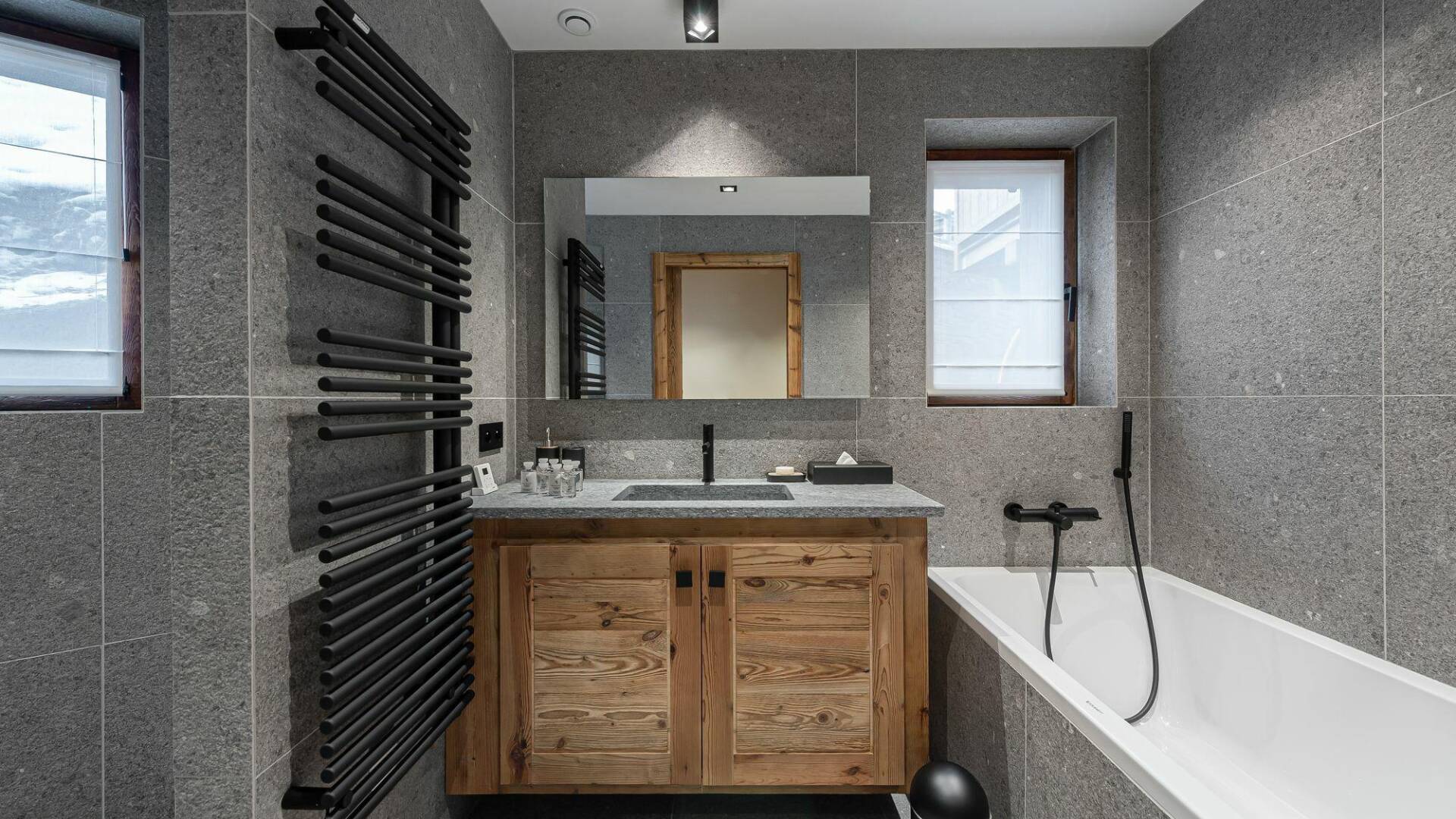 en suite bathroom with bath tub and towel dryer