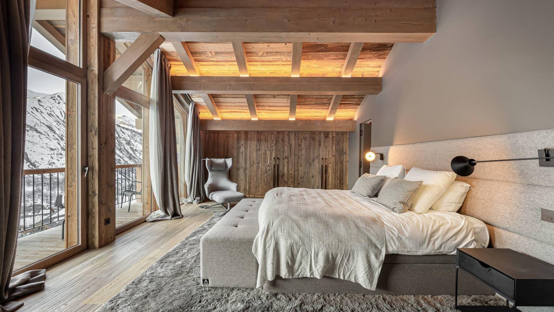 spacious master bedroom with exposed beam ceiling and scenic view 
