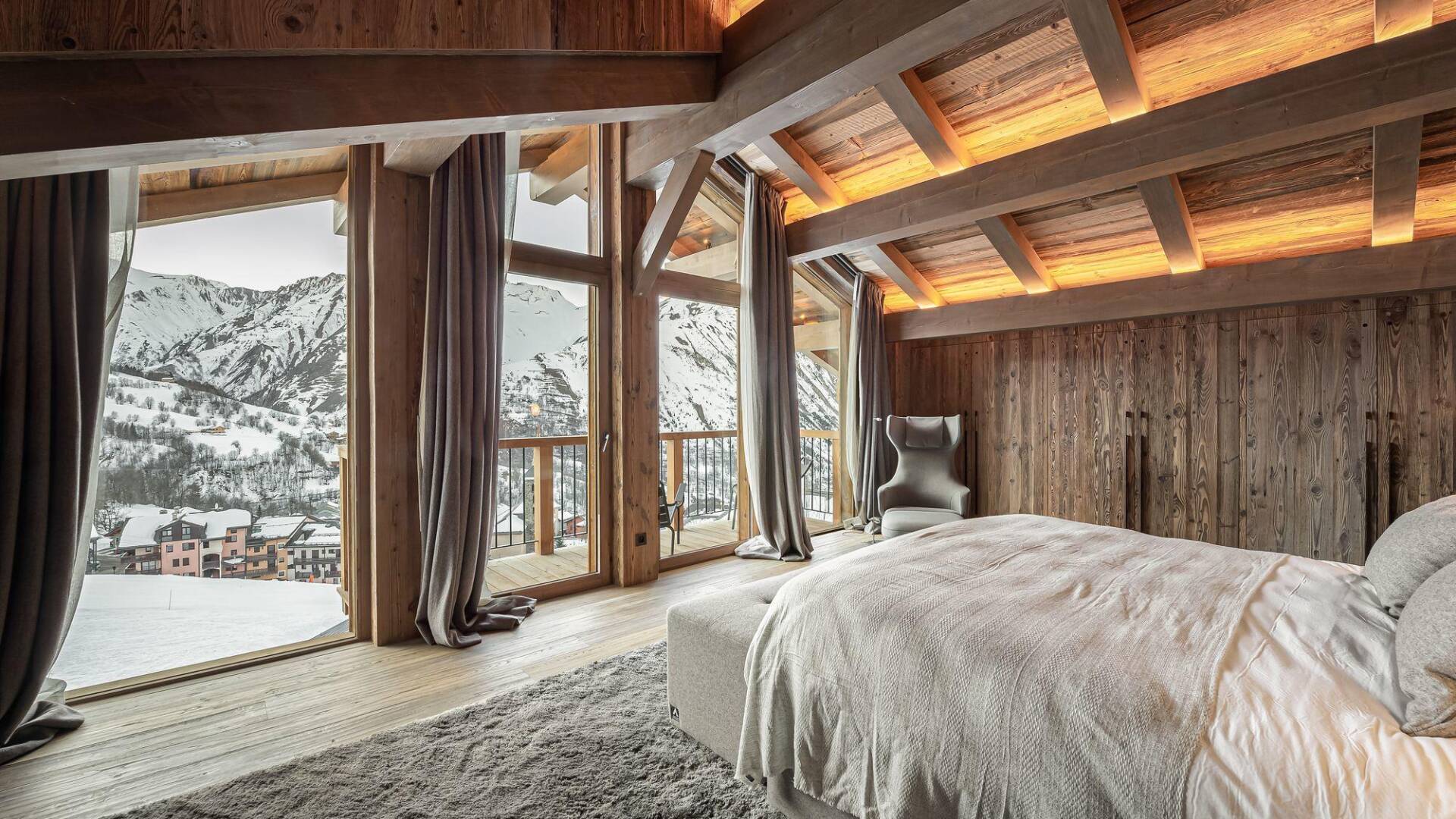 spacious master bedroom with exposed beam ceiling and a little balcony