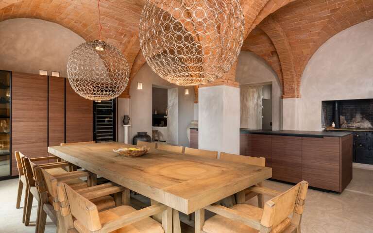 open space kitchen and dining room with exposed brick and vaulted ceilings
