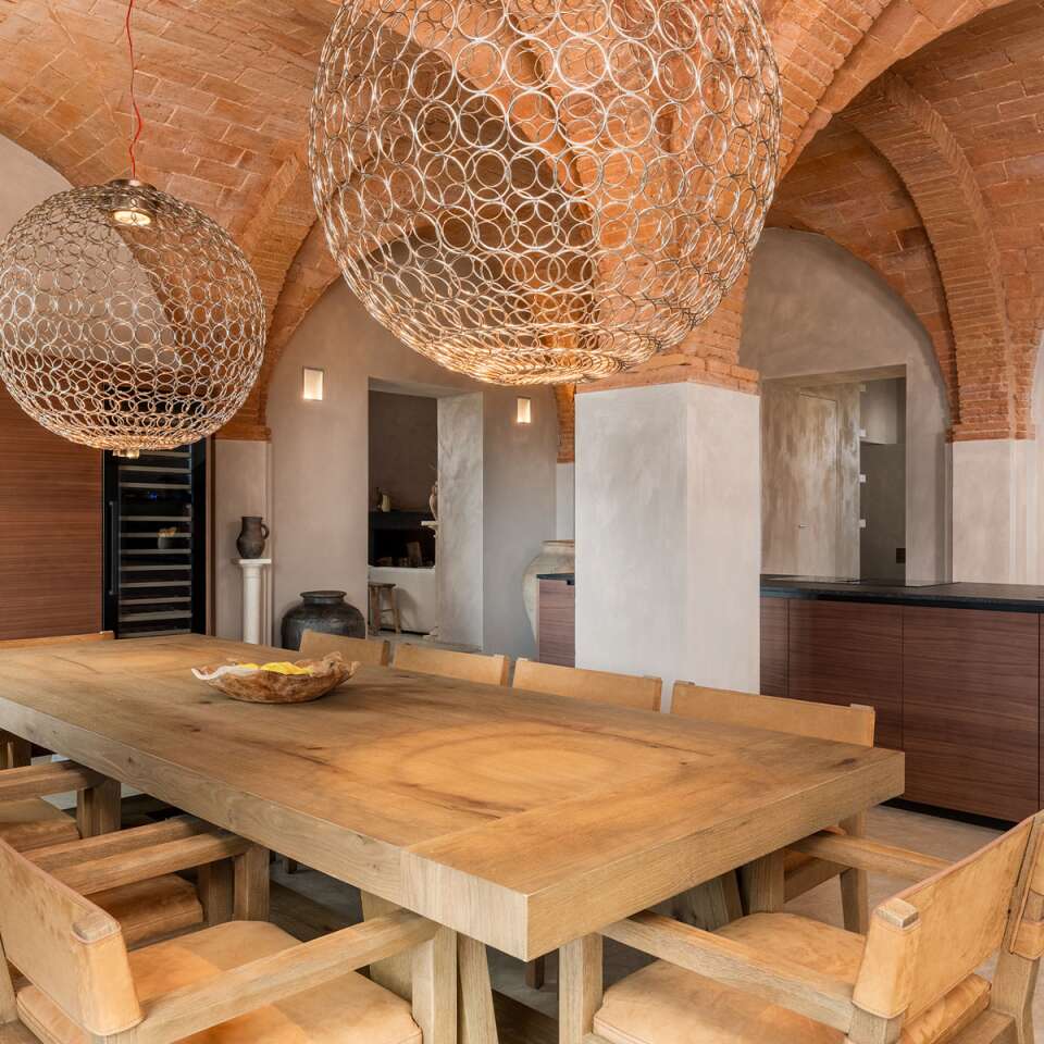 open space kitchen and dining room with exposed brick and vaulted ceilings