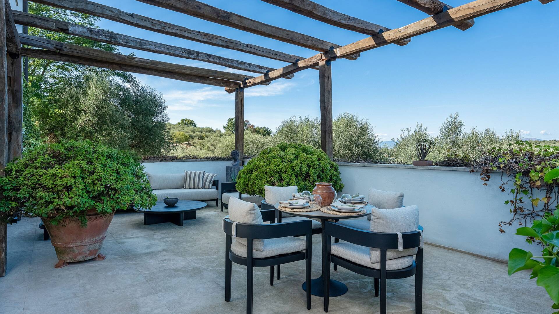 pergola with little dining table and lounge area