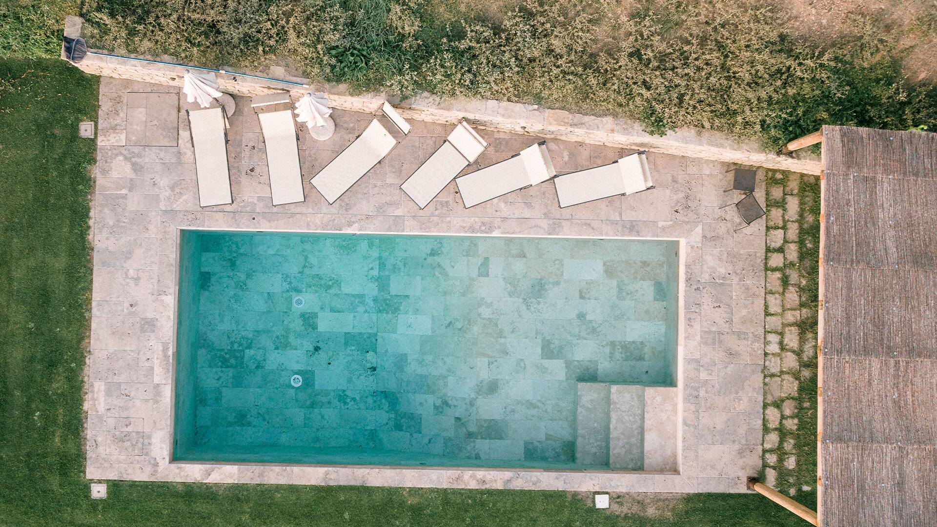 swimming pool area with sunbeds and pergola