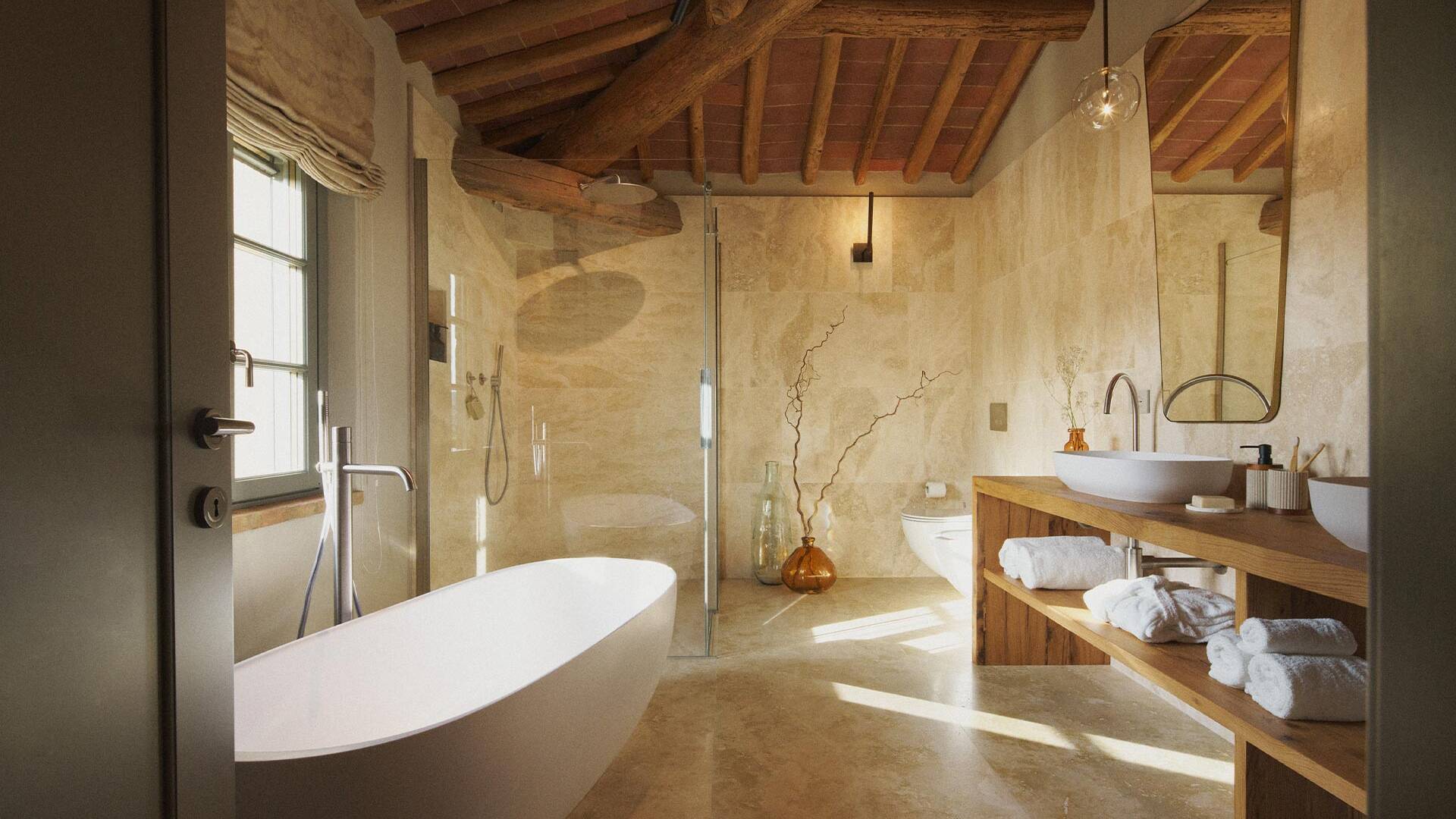 en suite bathroom with freestanding bathtub and Tuscan marble details