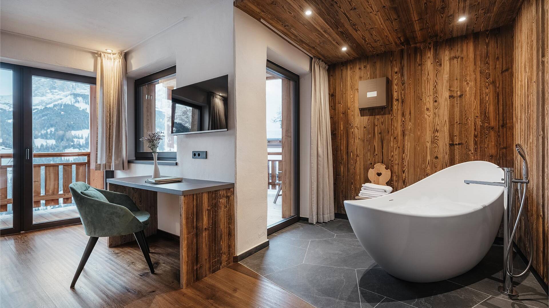 Chalet Acanto Fi double bedroom with en suite bathroom and freestanding bathtub