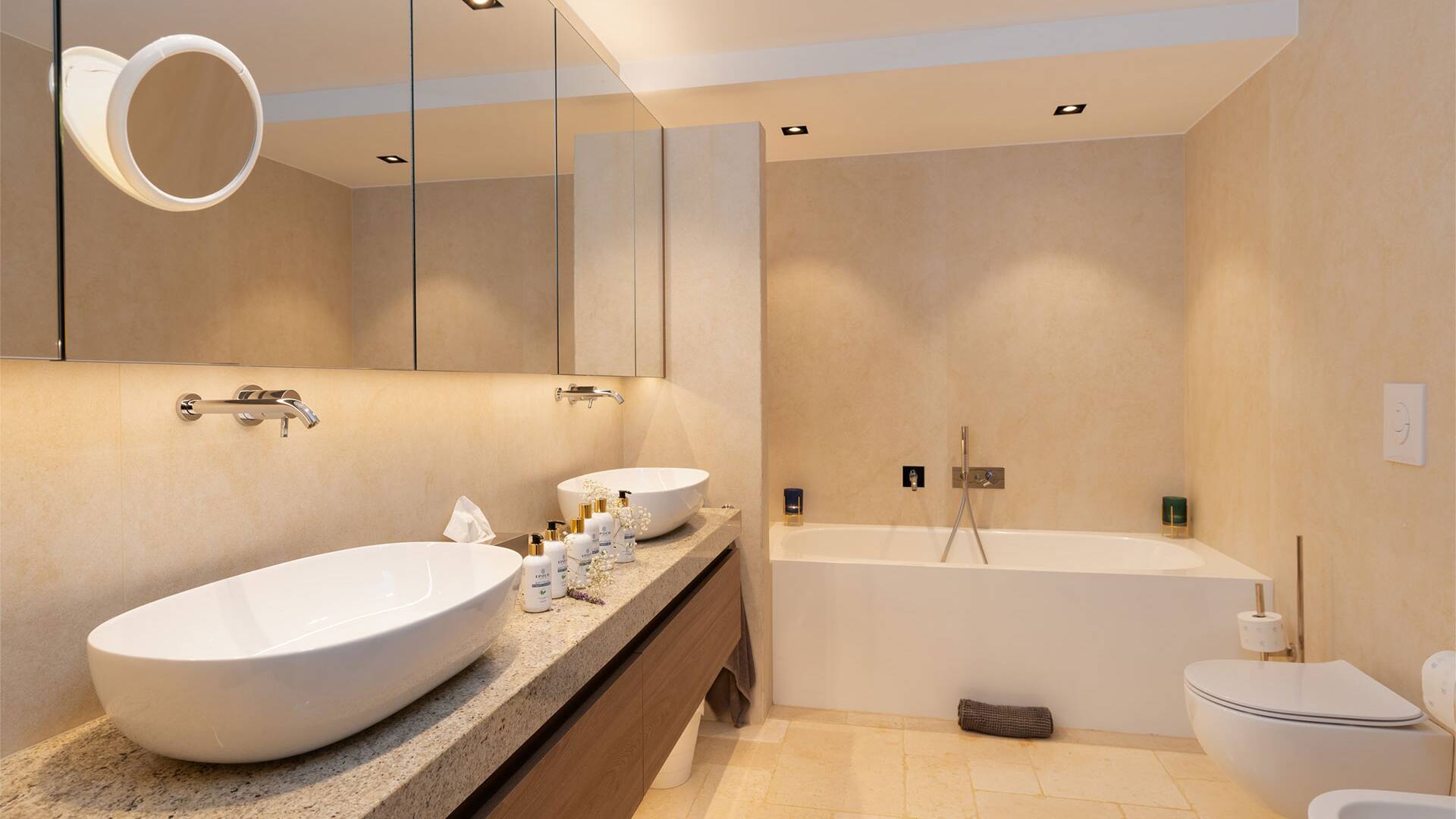 en suite bathroom with bath tub and double basin
