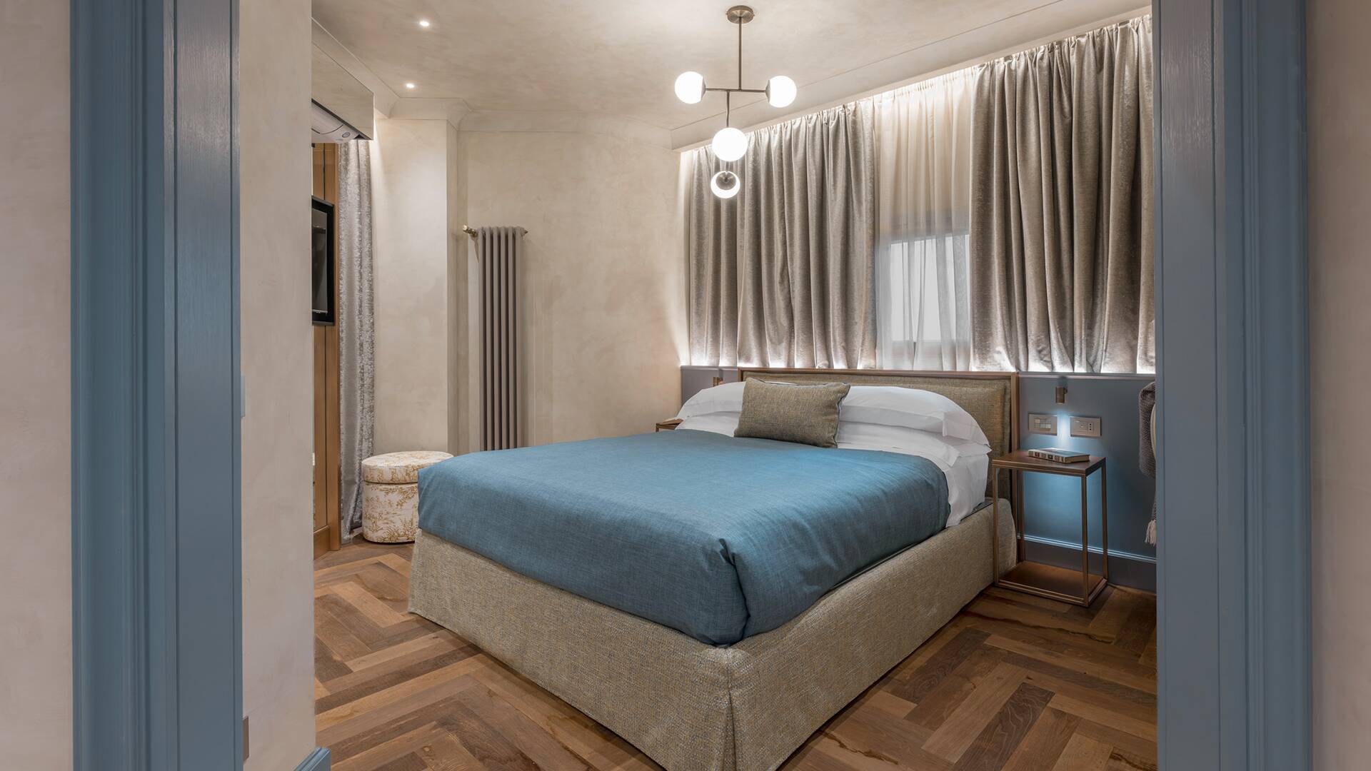 Contemporary bedroom with blue accents and parquet floors