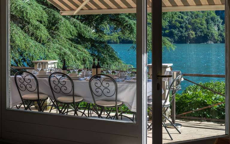 covered al fresco dining table with lake view