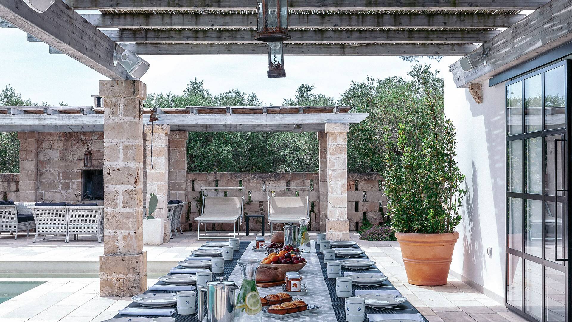 alfresco dining and sunbathing area by pool house