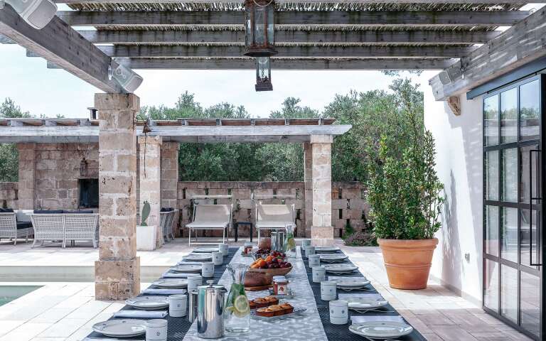 alfresco dining and sunbathing area by pool house