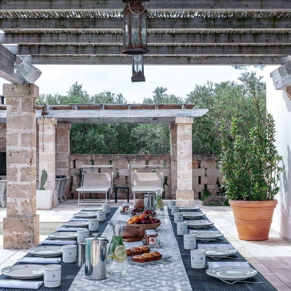 alfresco dining and sunbathing area by pool house