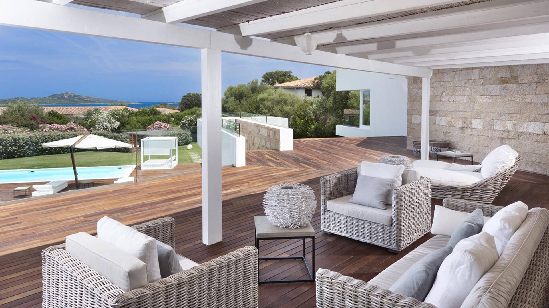 outdoor sitting area with pool and sea view