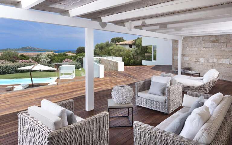 outdoor sitting area with pool and sea view