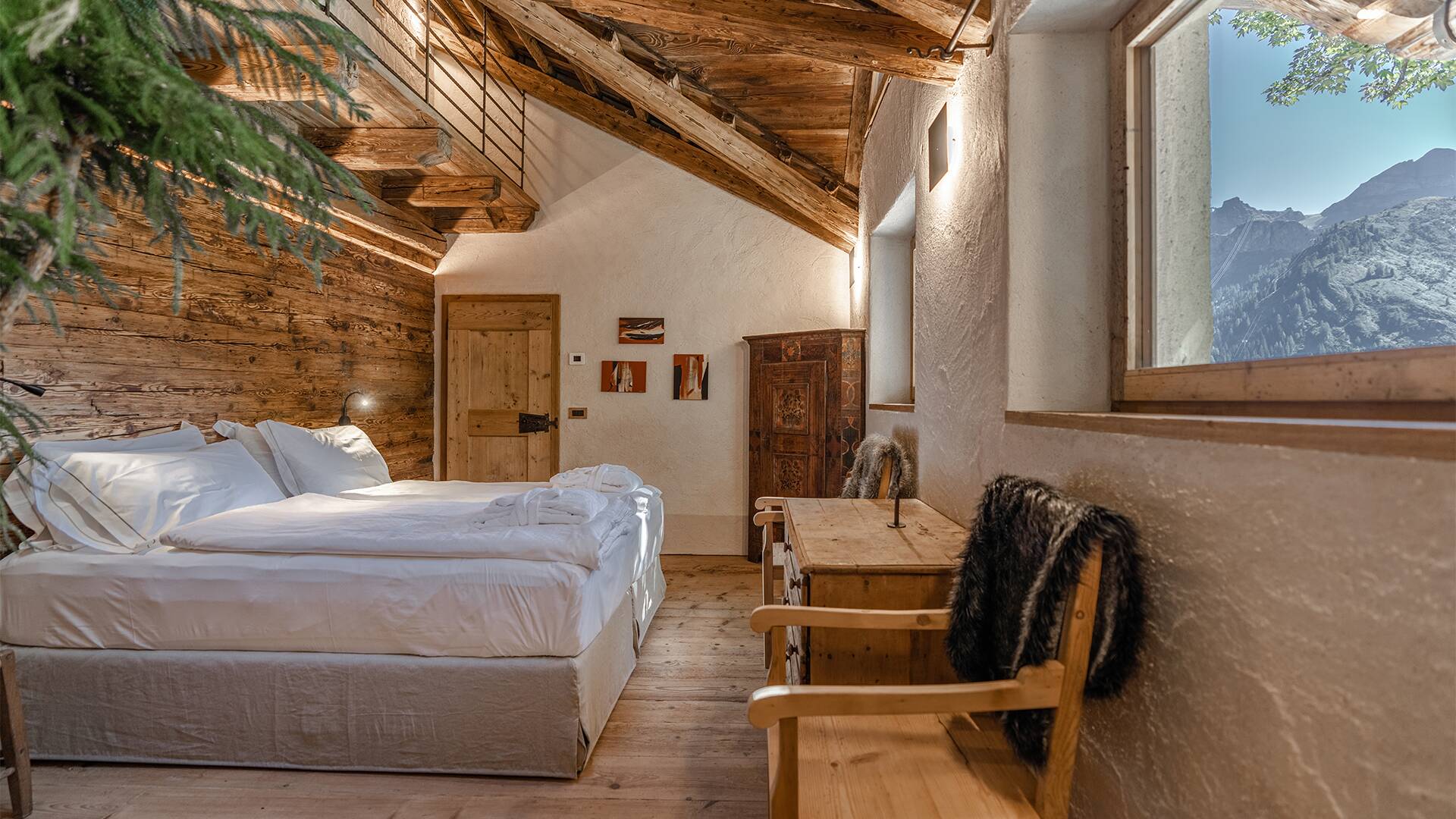 luxury double bedroom with wooden ceiling and mountain view