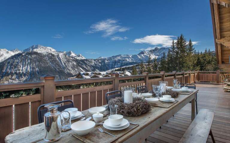 al fresco dining table with view over snowcapped French Alps