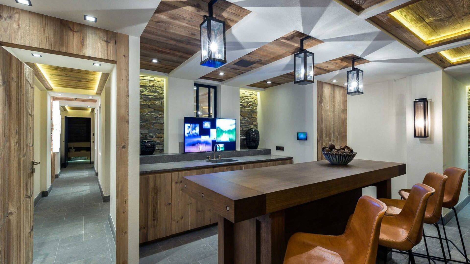 sleek corner bar with counter, stools and TV