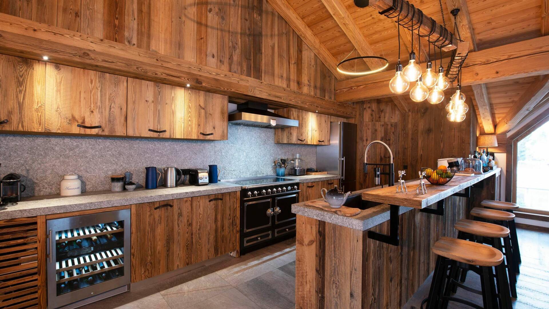fully equipped wooden kitchen with cooking island and stool