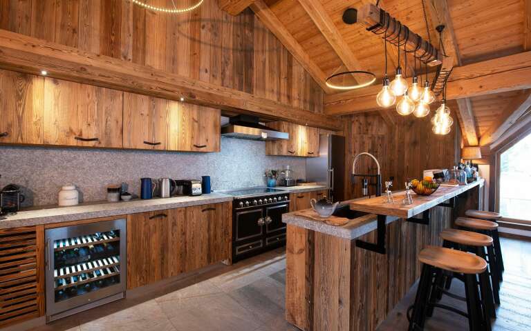 fully equipped wooden kitchen with cooking island and stool