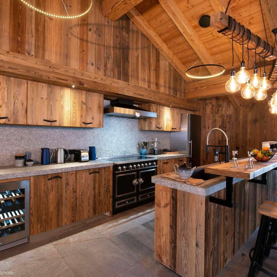 fully equipped wooden kitchen with cooking island and stool