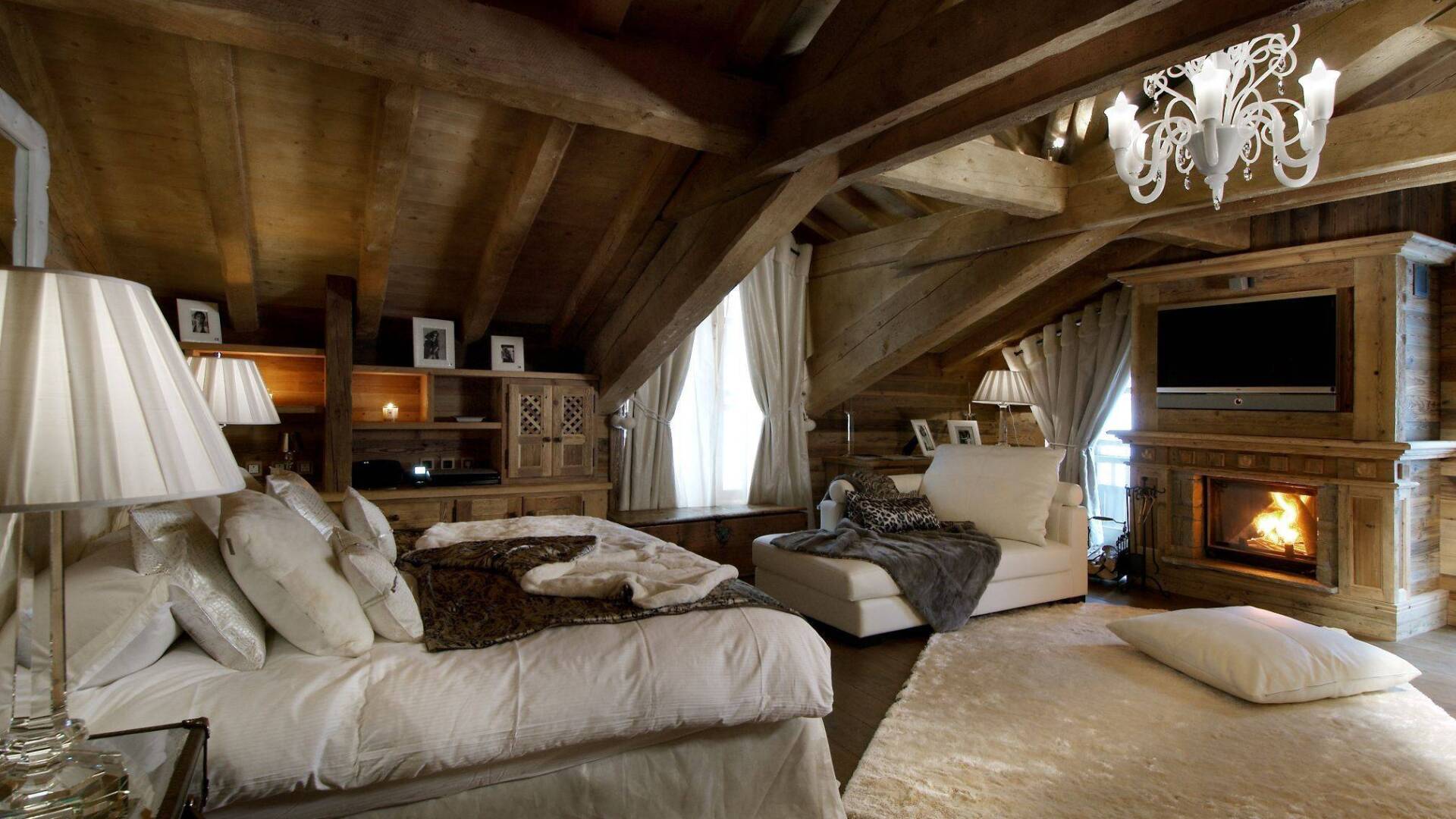 luxury double bedroom with sitting area, TV and fireplace