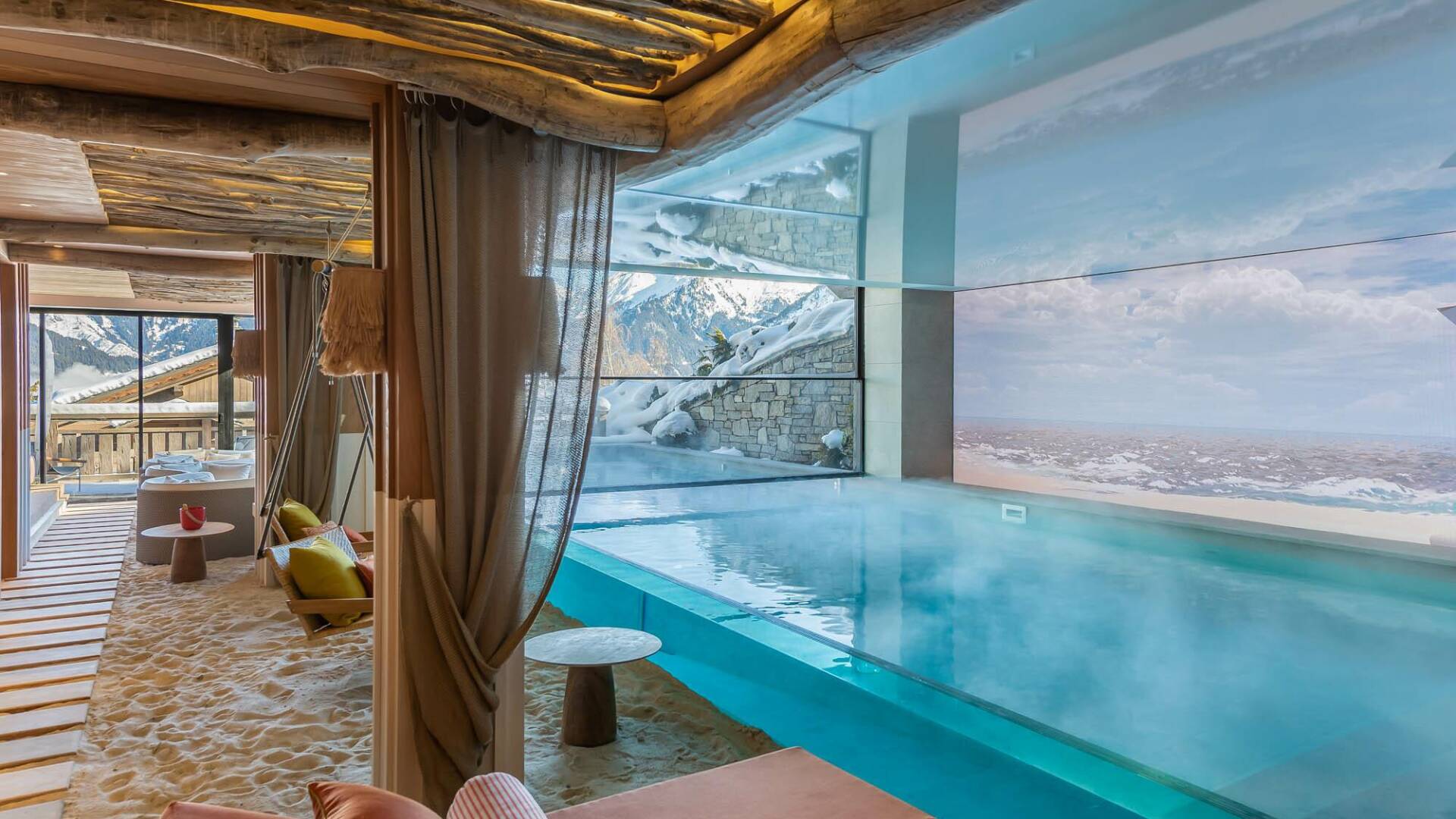 majestic indoor/outdoor pool with swings, sunbeds and white sand