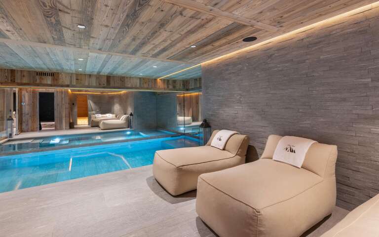 luxury indoor pool with cosy lounge area